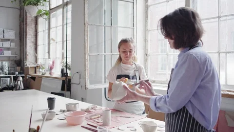 Two female ceramic artists talking while working in art studio Video stock 106832383