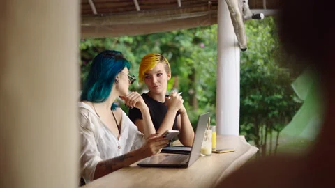 Two female co-workers have a conversation about their jobs while working Stock Footage 210805944