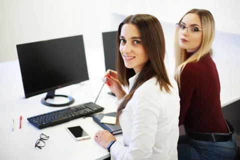 Two female colleagues in office working together. Stock Photos