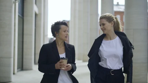 Two female colleagues walking down street and talking Stock Footage 96543205