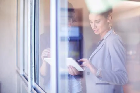 Two female creative professionals with  adhesive notes behind windowpane Stock Photos