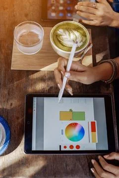 Two female designers work using a tablet and speical program outdoors Fotos Stock