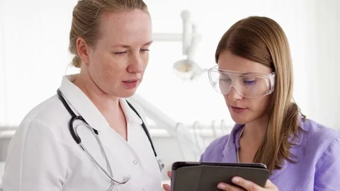 Two female doctors with tablet discussing new treatment at hospital room Stock-Footage 81554527