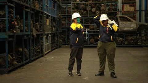 Two female engineers wearing safety gear inspecting car parts inventory Stock Footage 319841981