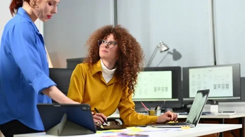 Two female fintech developers collaborating on finance apps, data analytics.. Stock Footage 312387335