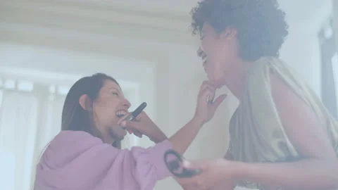 Two female friends doing makeup on each other, having fun. Stock-Footage 229529661