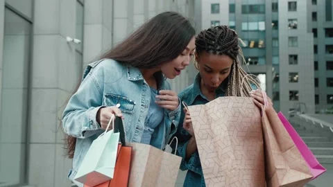 Two female friends with multi-colored bags. two young women after shopping share Stock Footage 157479531