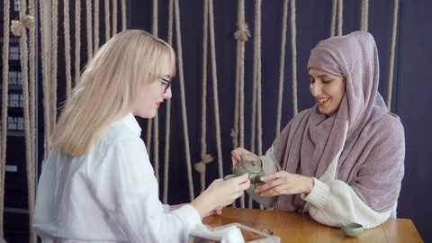 Two female friends at the table with tea cups. Stock Footage 107743751