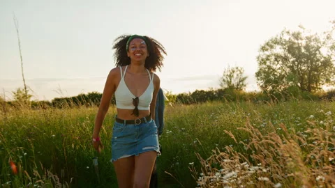 Two Female Friends Walking Pulling Trolley Through Field Towards Teepee On Stock Footage 312688735