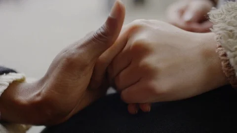 Two female hands come together and hold each other Stock Footage