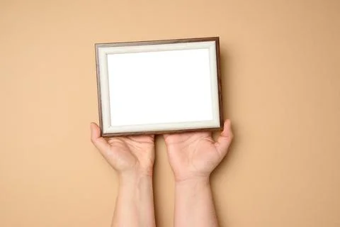 Two female hands holding a empty rectangular blank wooden frame Foto stock