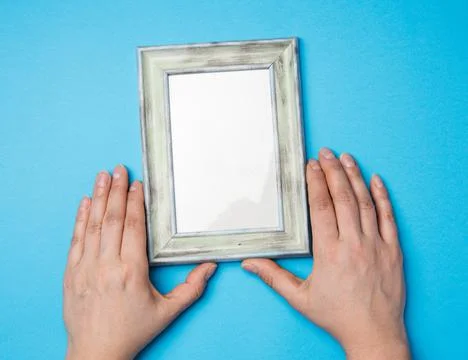 Two female hands holding a rectangular blank wooden frame Stock Photos