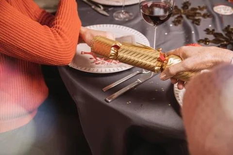 Two female hands pulling at ends of a Christmas cracker Stock Photos