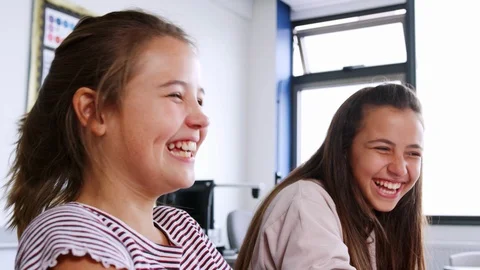 Two Female High School Students Laughing As They Sit In Classroom Stock Footage