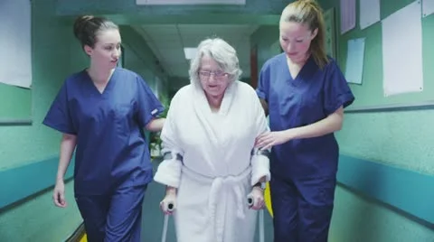 Two female medics help an elderly patient to take a walk Stock Footage