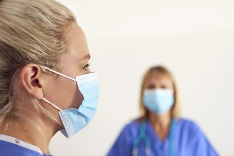 Two Female Member Of Medical Team Wearing Scrubs And PPE Face Mask And Gloves Stock Photos