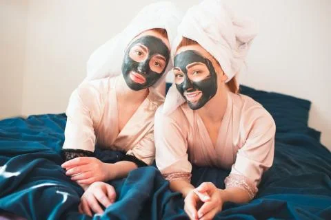 Two female models make face mask. Two young women in towels and pajamas have a Stock Photos
