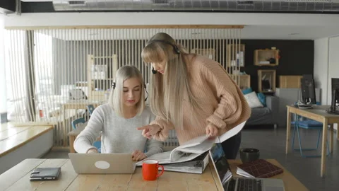 Two female office workers are checking documents in folder Stock Footage 108632451