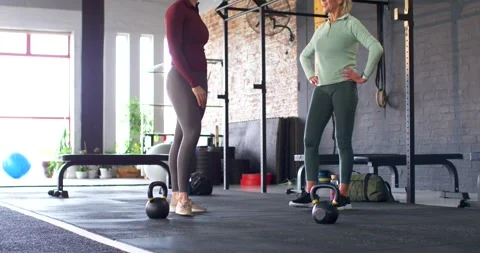 Two female partners coaching technique in gymwear while camera pulling back to Video stock 342032915