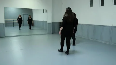 Two female plus size models in black clothes are dancing in the hall Stock Footage 244840419