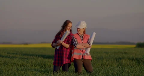 Two Female Smiling Engineers holding Blueprints at Farm Stock Footage 204051580