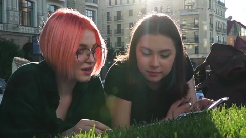 Two female students studing in the park Stock Footage 140043164