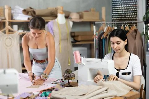 Two female tailors creating custom garments in workshop Stock Photos