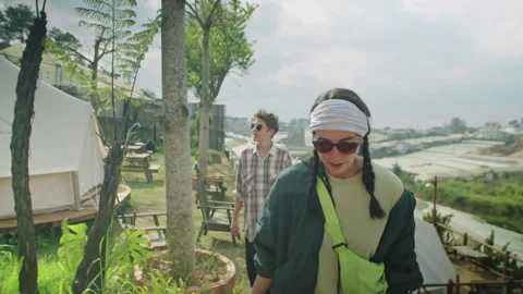 Two Female Tourists Walking through Glamping and Discussing View Stock Footage 244879697