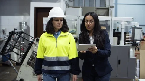 Two female workers walking with tablet at factory Video stock 127348023