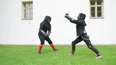 Two fencers dressed in black protective uniforms, helmets with face masks next t Video stock 309204143