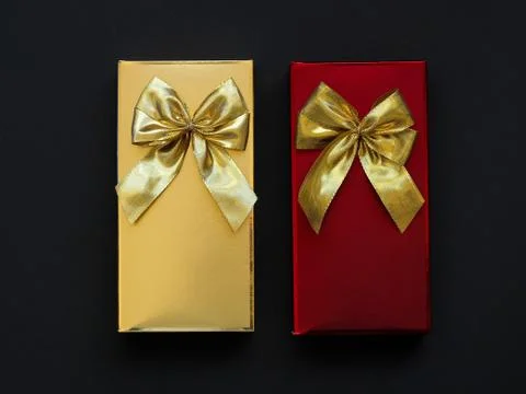 Two festive gift boxes of chocolates on a black background. 写真素材