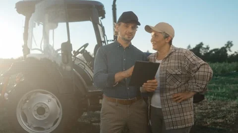 Two field workers having professional discussion. Man and woman standing at Stock Footage 254095499