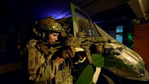 Two fighters, moving with weapons, coordinate actions in an underground shelter. 스톡 동영상 304115279