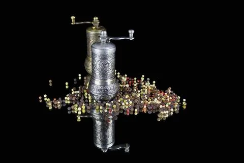Two figured silver pepperpots and little pepper balls scattered around Stock Photos