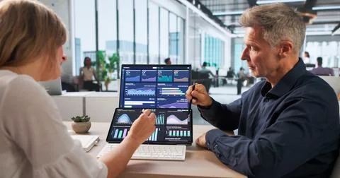 Two Finance Analysts Working Closely Together, Analyzing Market Data Insights Stock Photos