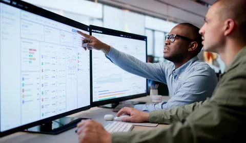 Two Financial Analysts Use Cloud Software For Invoice Processing Teamwork. Stock Photos