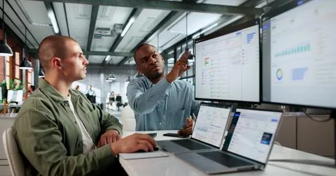 Two Financial Analysts Using Cloud Software On Laptops Discussing Cashflow Fo Stock Photos