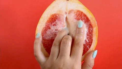 Two fingers in a grapefruit isolated on a red background top view sex concept Stock Footage 113104758