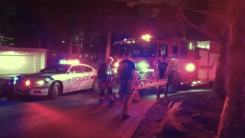Two fire emergency service crew carry strecher at night after an accident in Stock Footage 301043351