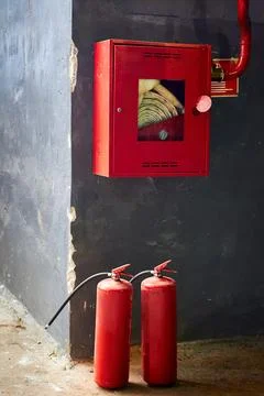 Two Fire extinguishers and fire hose in red metal box. Fire protection equi.. Stock Photos