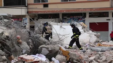 Two fire fighters walking through rubble of collapsed building, 2016 Ecuador Vidéo 62830759