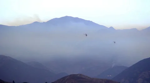 Two fire rescue helicopters heading into smoke Stock Footage 66778225