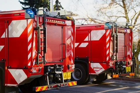 Two fire trucks positioned with visible ladders, reflective graphics 스톡 사진