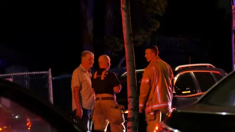 Two firefighters chatting with drunk men Stock Footage 116712573