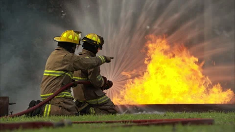 Two firefighters kneel in position while directing a powerful water Stock-Footage 326217983