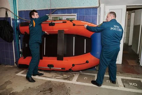 Two firefighters prepare a special inflatable boat for an emergency trip to the Stock Photos