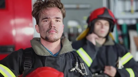 Two firefighters in protective uniform puts off red helmets Stock Footage 276368520