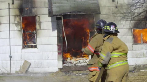 Two firemen get ready to hose down flames Stock Footage 60984261