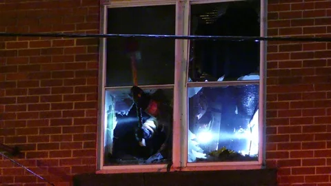 Two firemen inside dark building breaking windows and frames Stock Footage 85296385