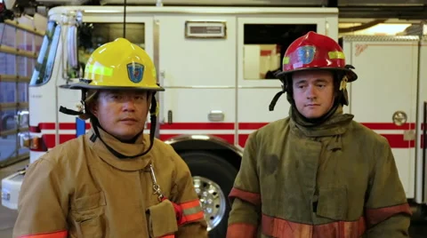 Two firemen putting on helmets and folding arms, portrait Stock Footage 66548678